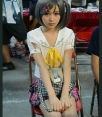 男孩子化妆成女人的模样和穿着女人的服装坐在椅子上