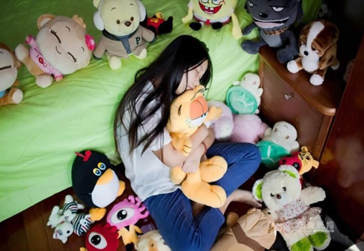 单身女孩章婷抱着一堆毛绒玩具的样子