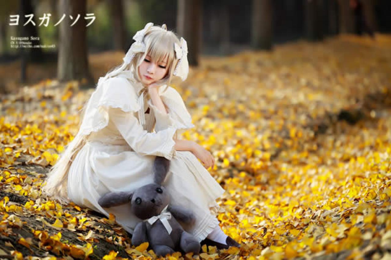 穹妹带着心爱的玩偶在落叶中休息