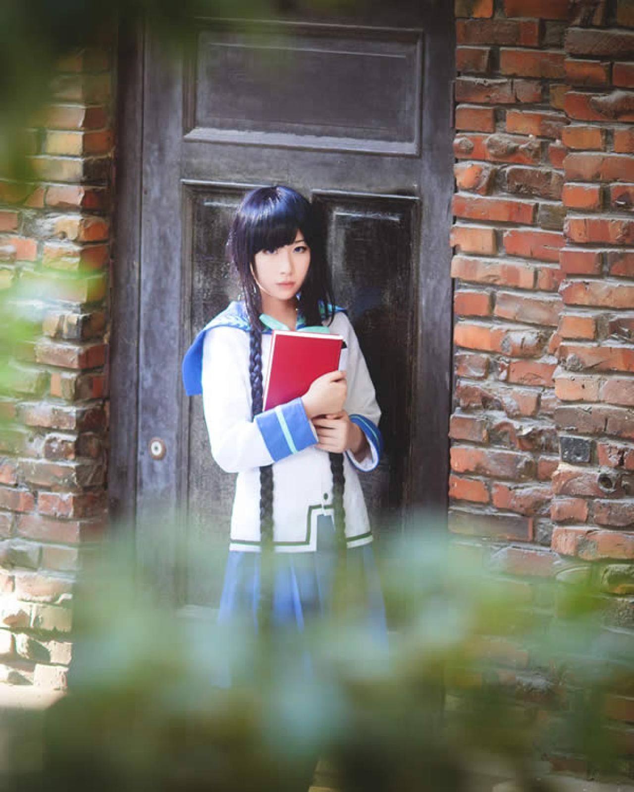 月歌Cos文学少女抱着一本红色的书在门口站着