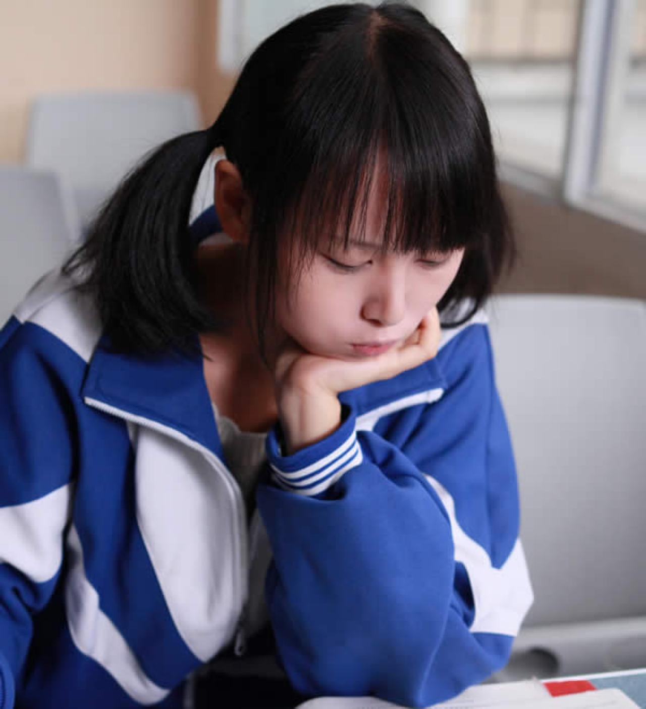 双马尾的小梓酱单手扶住下巴嘟嘴卖萌状