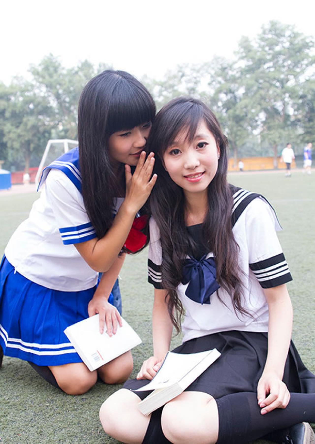 姊妹校服篇妹妹扶着姐姐的耳朵偷偷讲悄悄话的样子