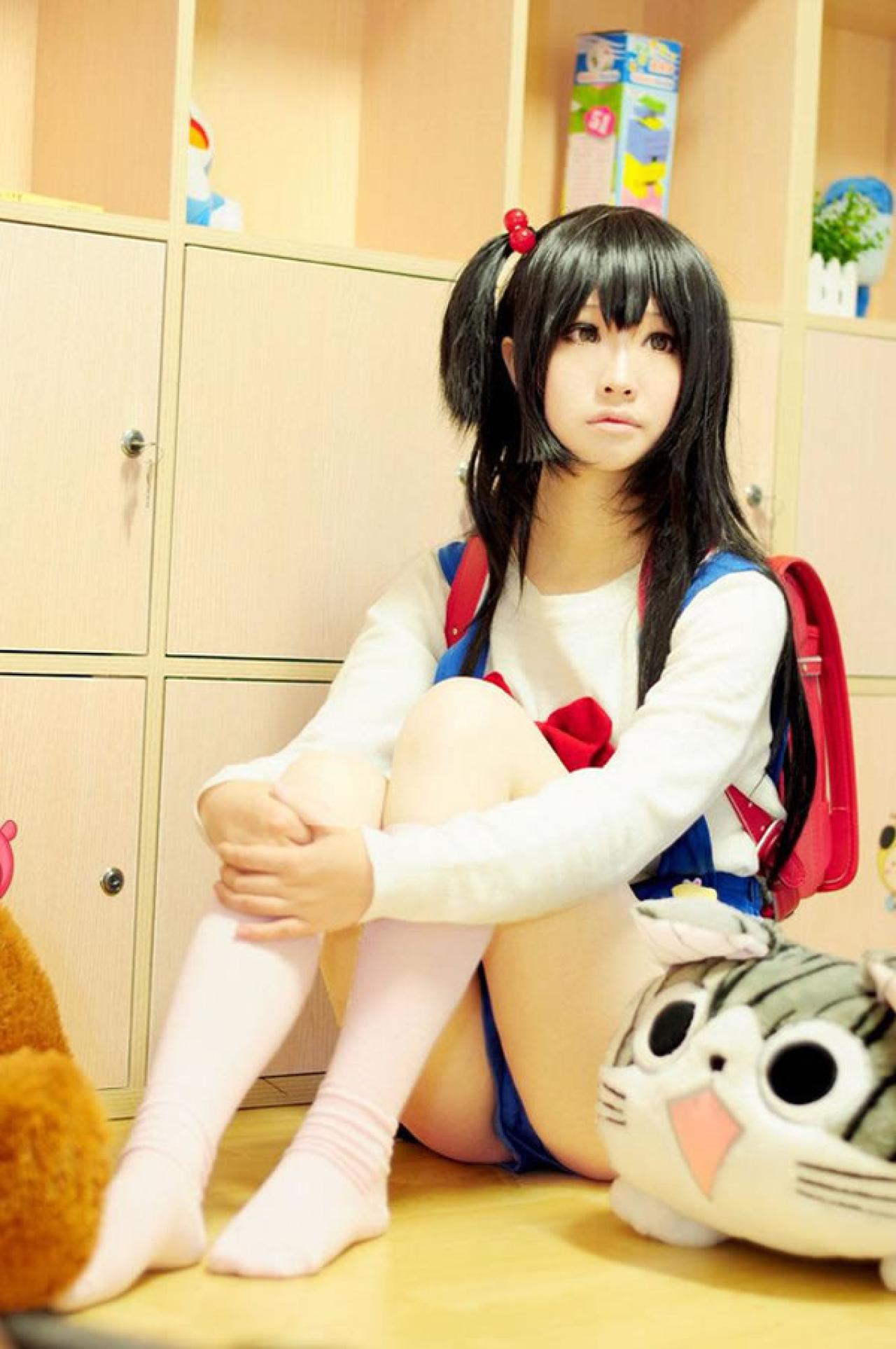 小赞Cos北白川馅子背着红色小书包坐在地上，旁边放着甜甜私房猫的膝枕