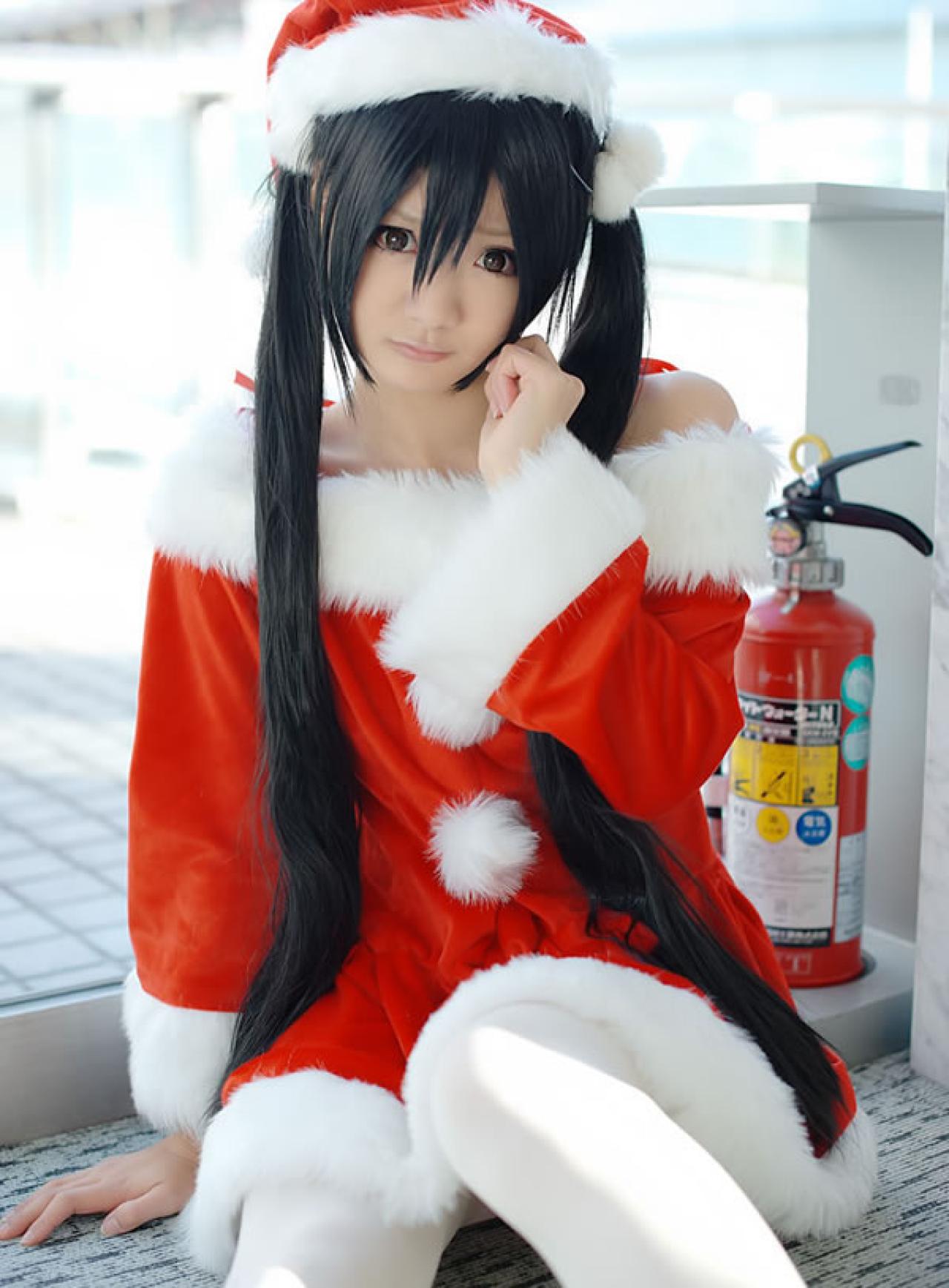 Maika Cos喵梓酱坐在地上，一只手扶住地面，另一只手触摸脸庞