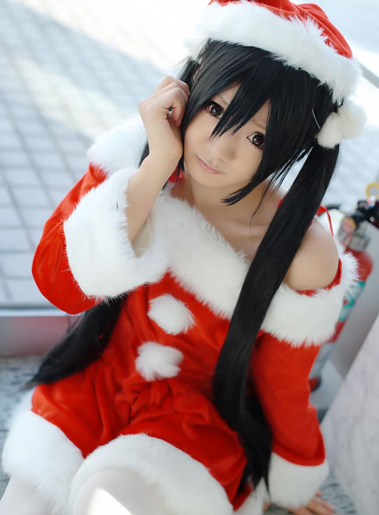 Maika Cos喵梓酱坐在地上，一只手扶住地面，另一只手触摸脸庞，换了一个方位的照片