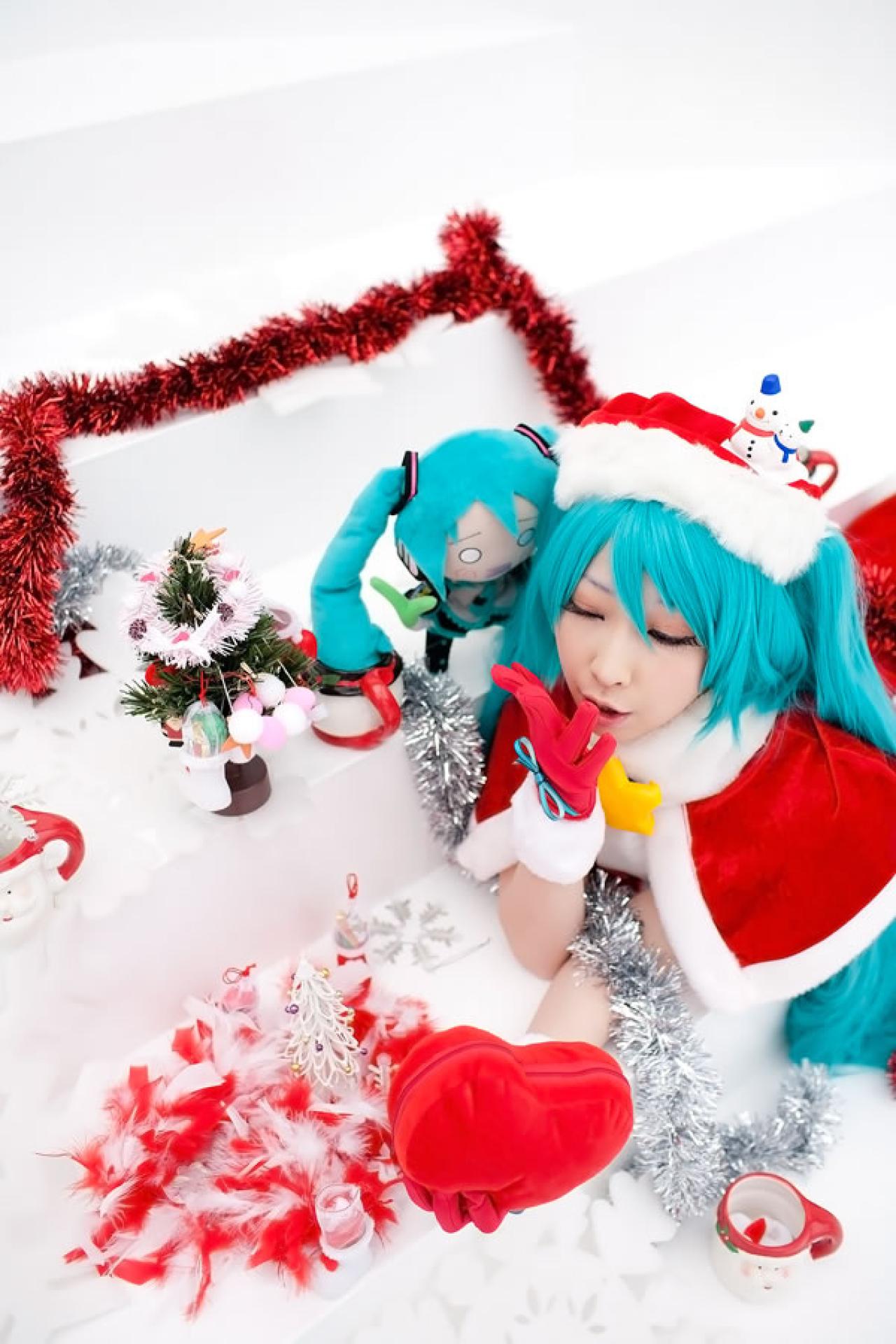 Miiko穿着初音圣诞礼服，一手拿着红色心形礼包，小葱娘靠在她的脸旁