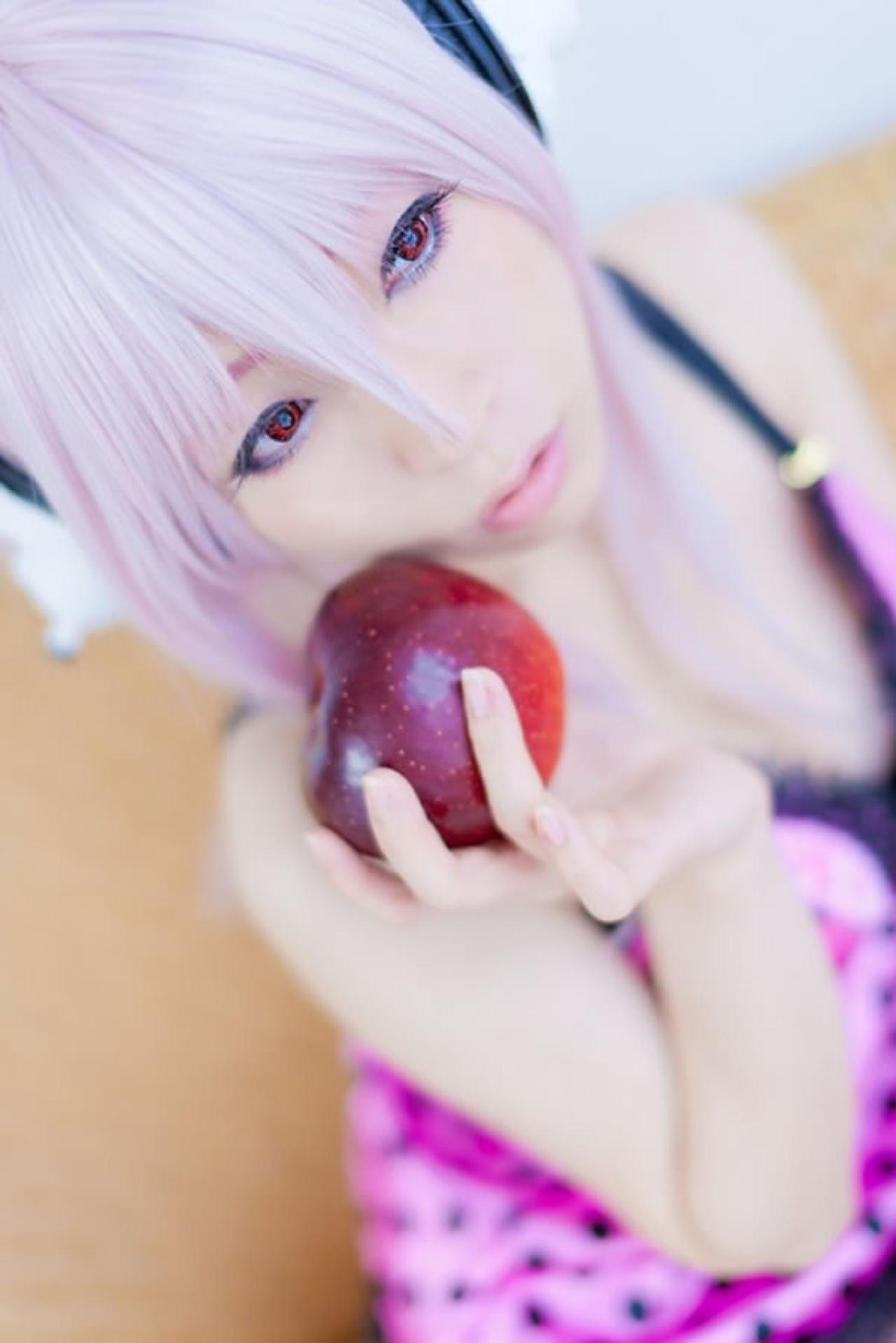 K@ori扮演超级索尼子戴着耳机穿着粉色吊带将苹果靠在脸颊特写