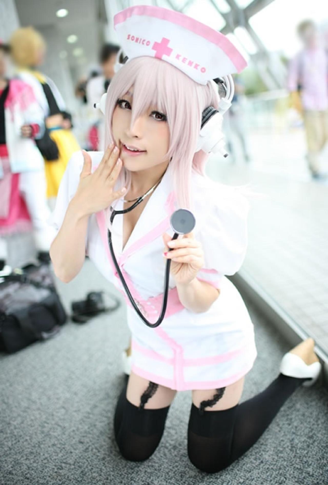 K@ori扮演超级索尼子身穿白色护士服跪在地上拿着听诊器的样子