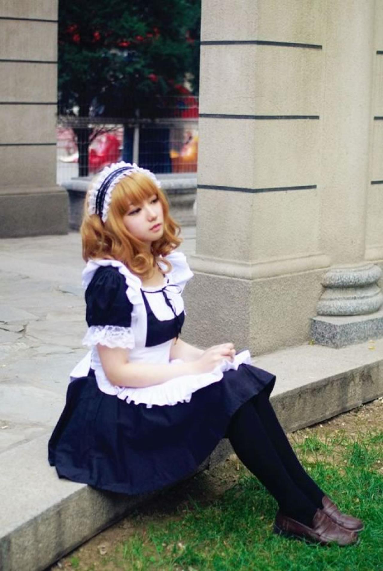 王雯雯Febii黄色卷发黑色女仆装坐在欧式长廊的台阶上向远处撇去的样子