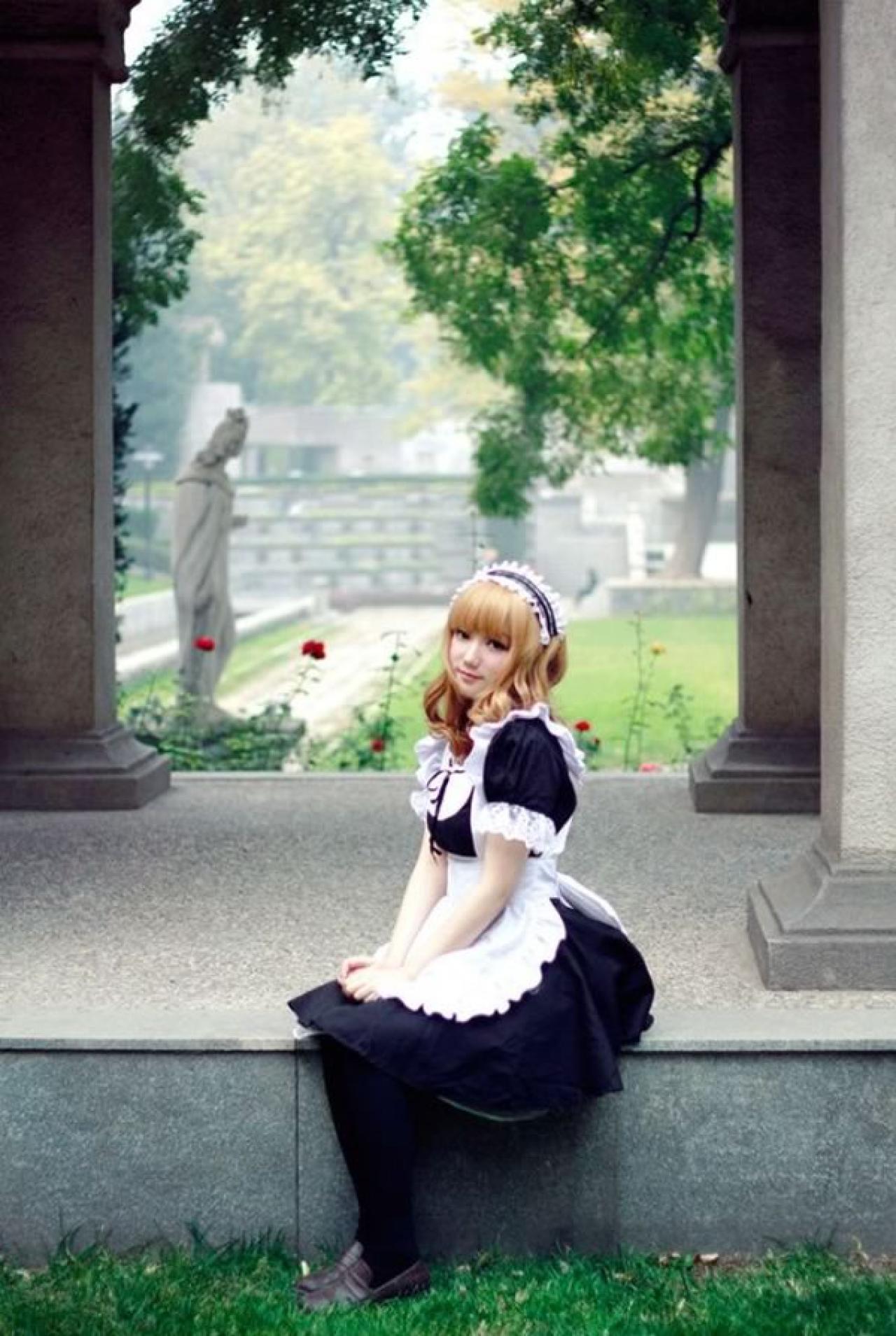 王雯雯Febii黄色卷发黑色女仆装坐在欧式长廊的台阶上微笑的样子正面照