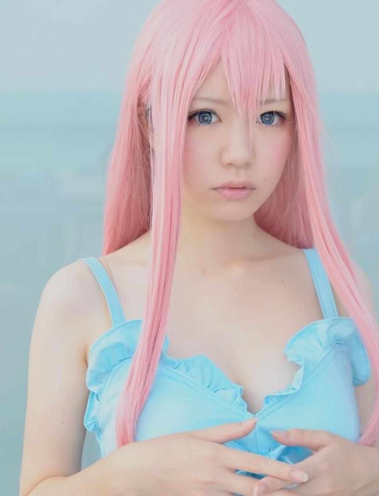 Miyabi粉色短发身穿淡蓝色短裙扮演巡音露卡双手放在胸前，插在一起，嘟嘴疑惑的样子