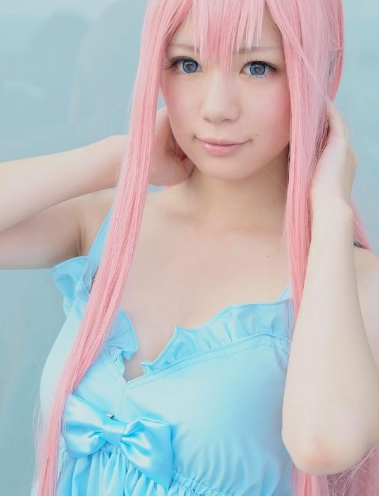 Miyabi粉色短发身穿淡蓝色短裙扮演巡音露卡双手背后，头靠在手上，很放松的样子