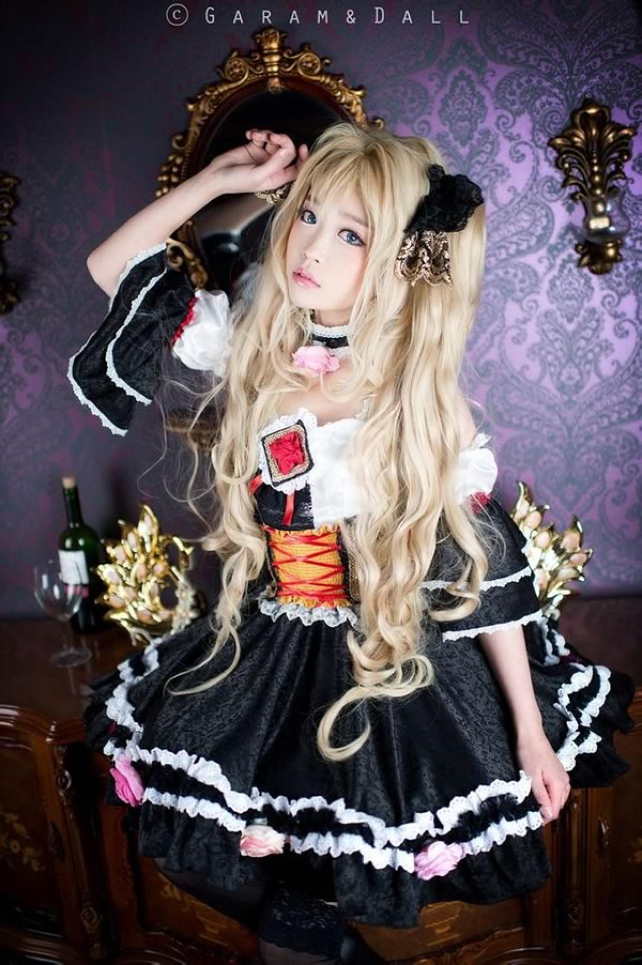 兔娘Tomia穿着黑白洋装一手抬起举过头顶，一手自然放在裙摆上