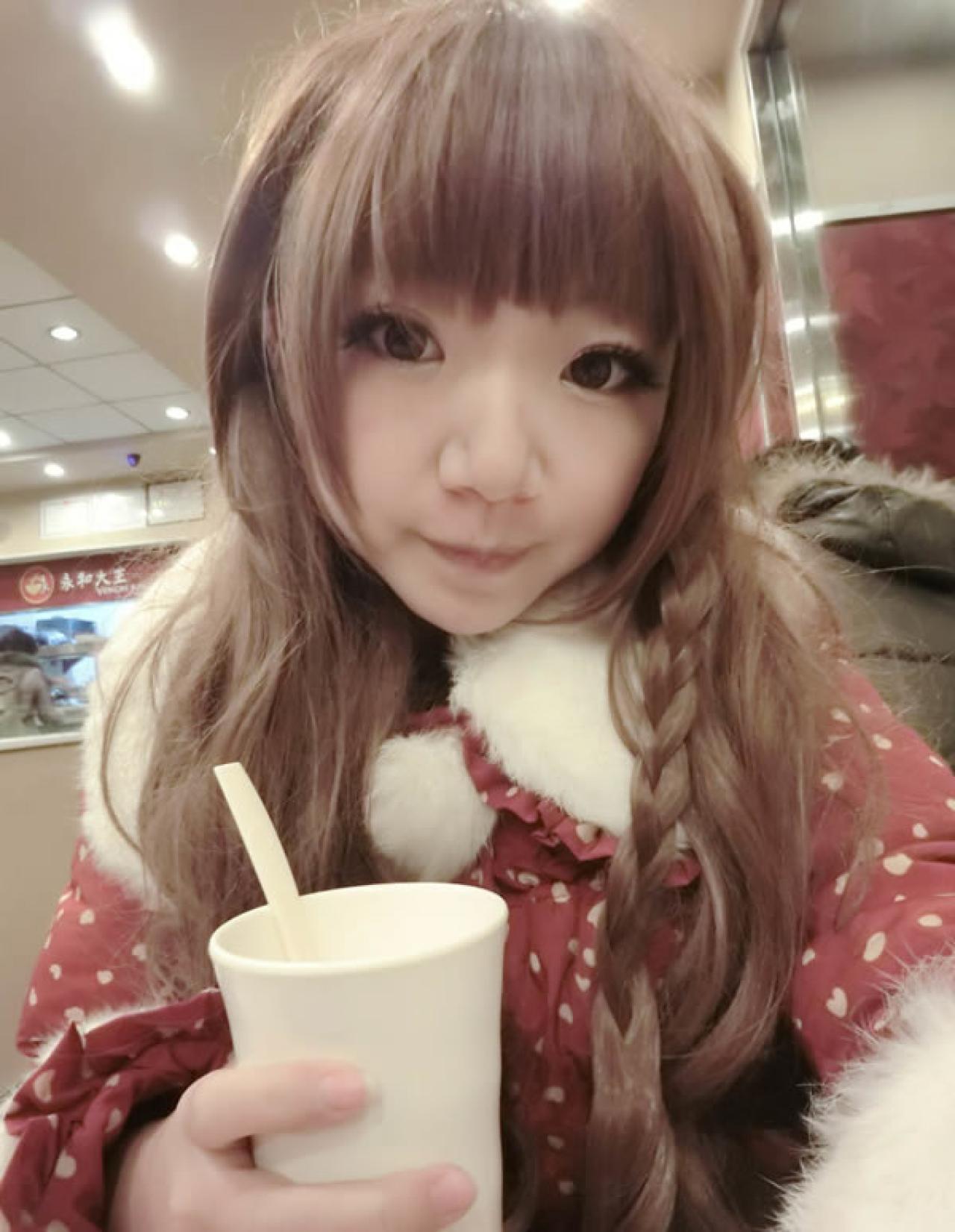 哀绿在13年12月24日平安夜晚在餐厅身穿红色桃心棉服的照片，嘟嘴卖萌，手拿饮料杯