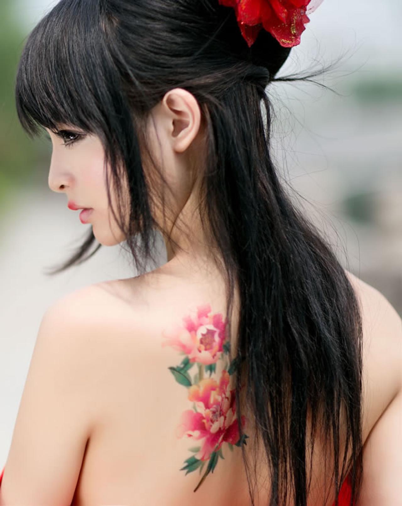 歪歪穿着大红色绸缎，背部两朵花特写