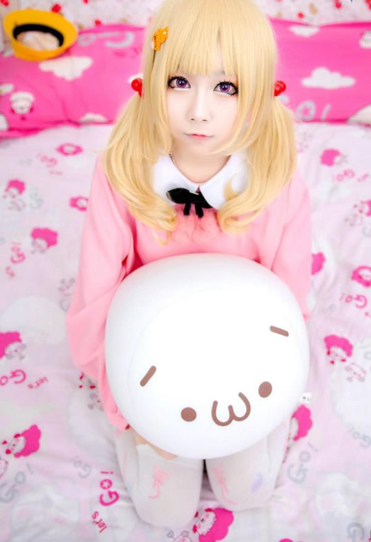 小甜幼稚园Cosplay穿着粉衣抱着嘟嘴小抱枕坐在沙发床上