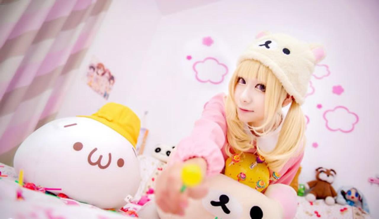 小甜幼稚园Cosplay穿着粉衣带着小熊帽子拿着一颗黄色棒棒糖，怀抱着一盒真知棒