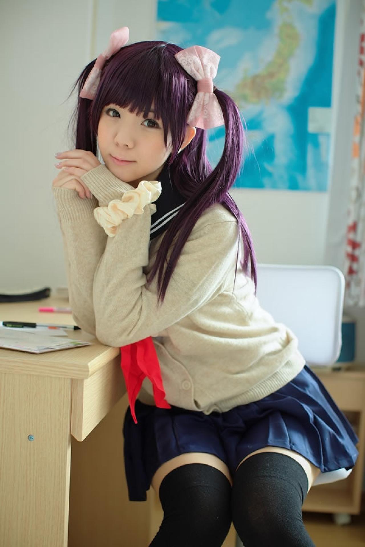 香坂ゆん扮演京野明日香身穿水手服和米色羊毛衫身体倚着书桌，正面看着镜头