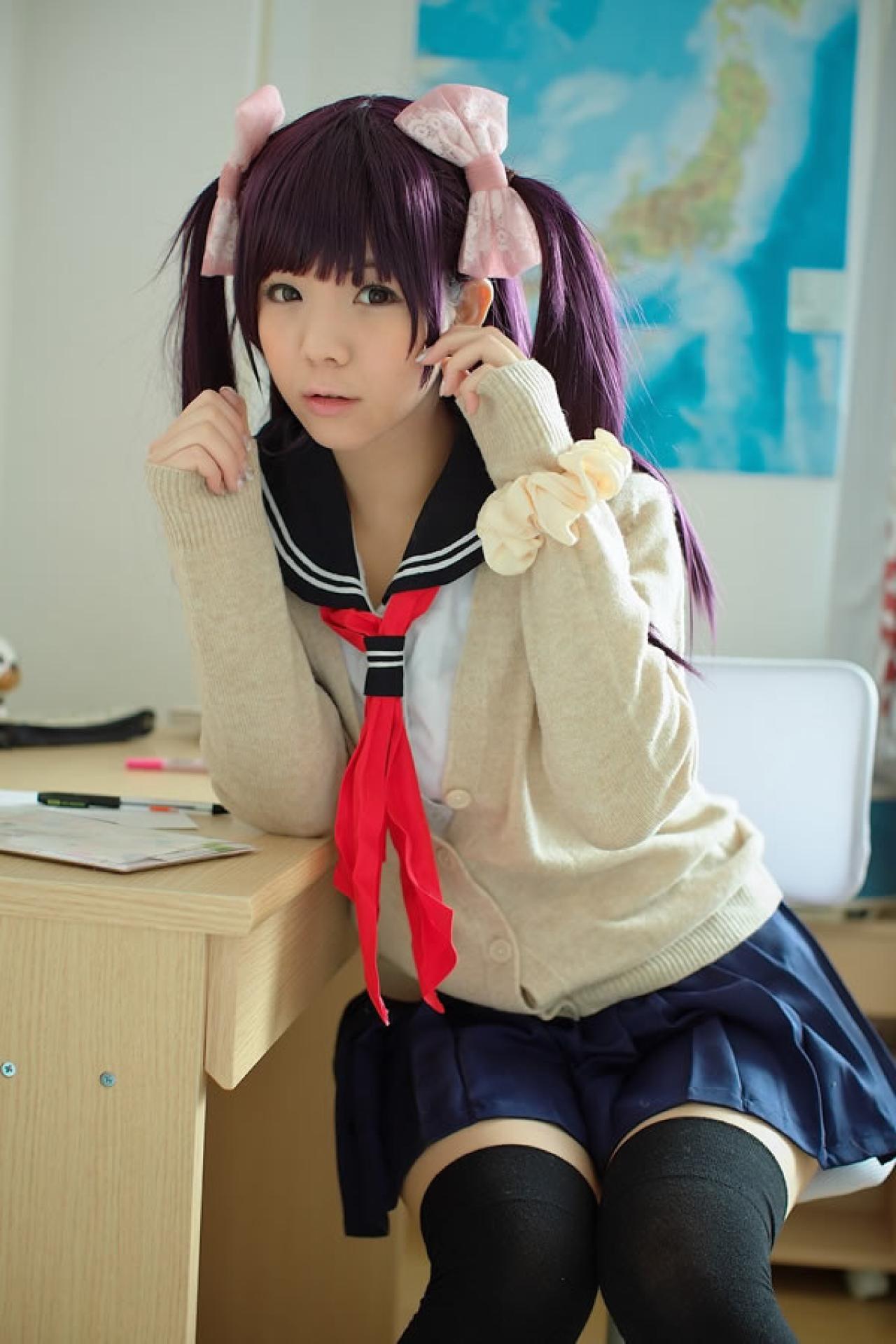 香坂ゆん扮演京野明日香身穿水手服和米色羊毛衫两只胳膊轻轻从书桌抬起，做出略吃惊的样子