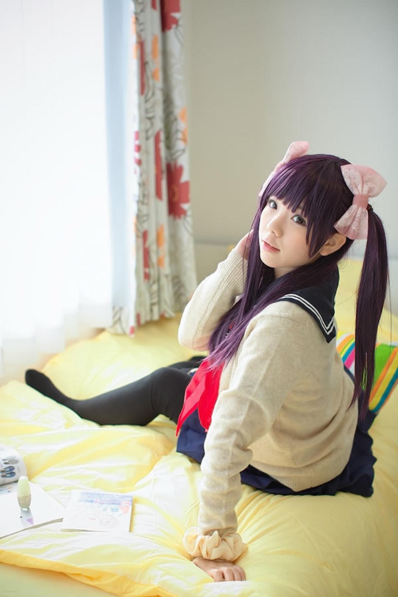 香坂ゆん扮演京野明日香身穿水手服和米色羊毛衫，坐在床上的背影，回头看镜头