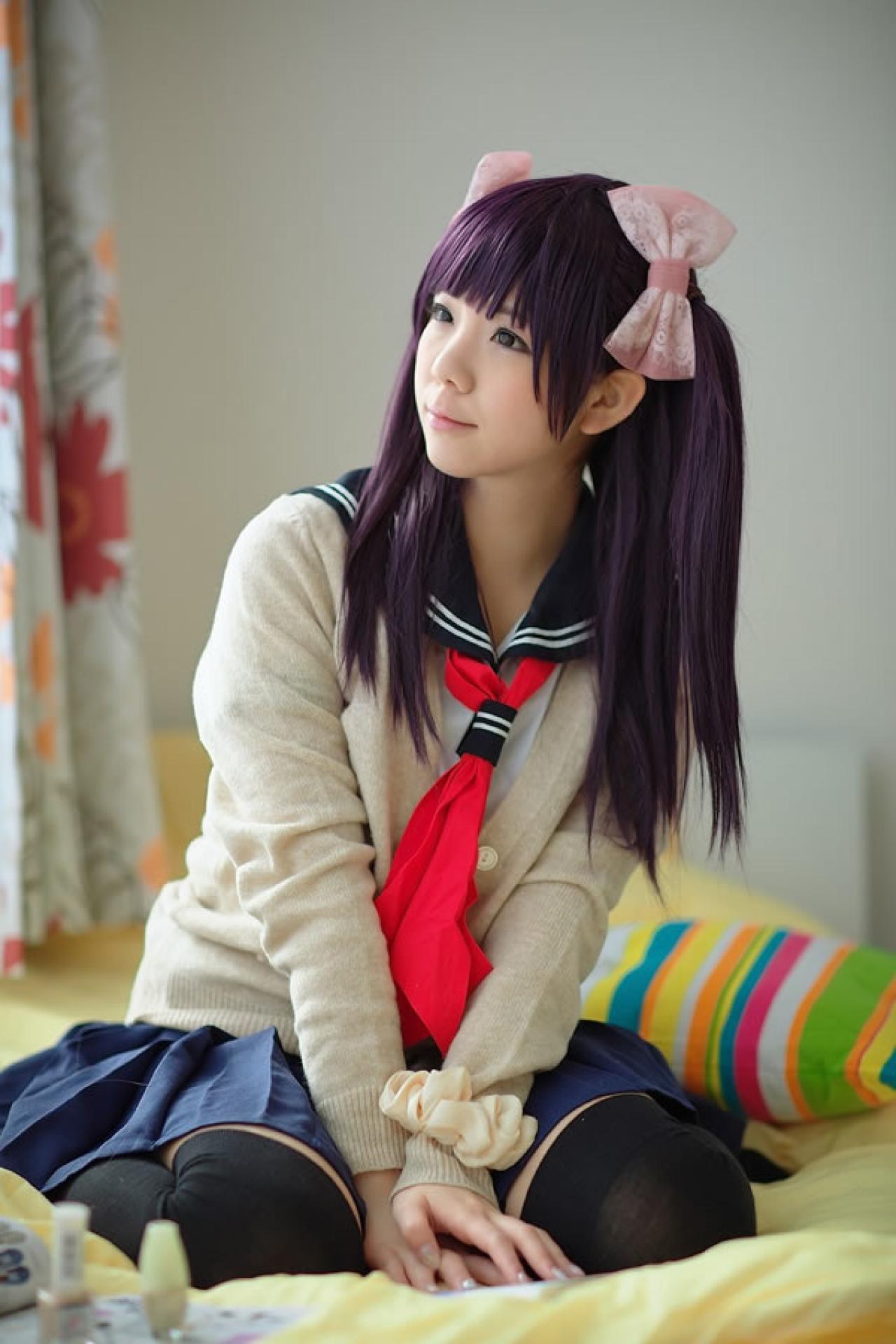 香坂ゆん扮演京野明日香身穿水手服和米色羊毛衫，坐在床上，看着窗外