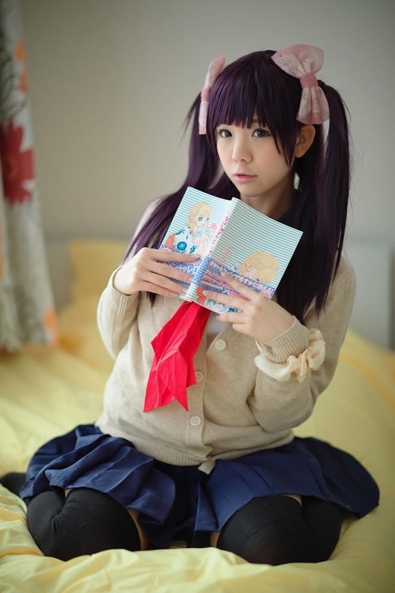 香坂ゆん扮演京野明日香身穿水手服和米色羊毛衫，把书放在胸前