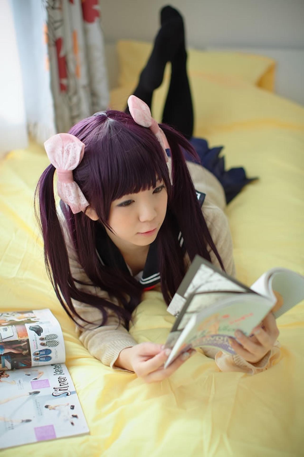 香坂ゆん扮演京野明日香身穿水手服和米色羊毛衫，全身趴在床上，津津有味的看着书