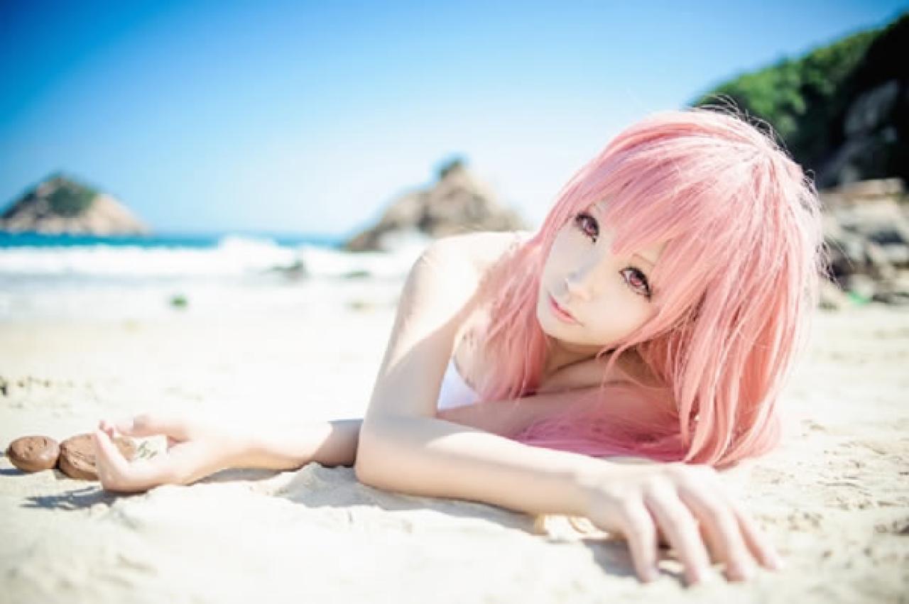 桜木梨扮演锁部叶风穿着白色抹胸趴在沙滩上，小泥人在手旁