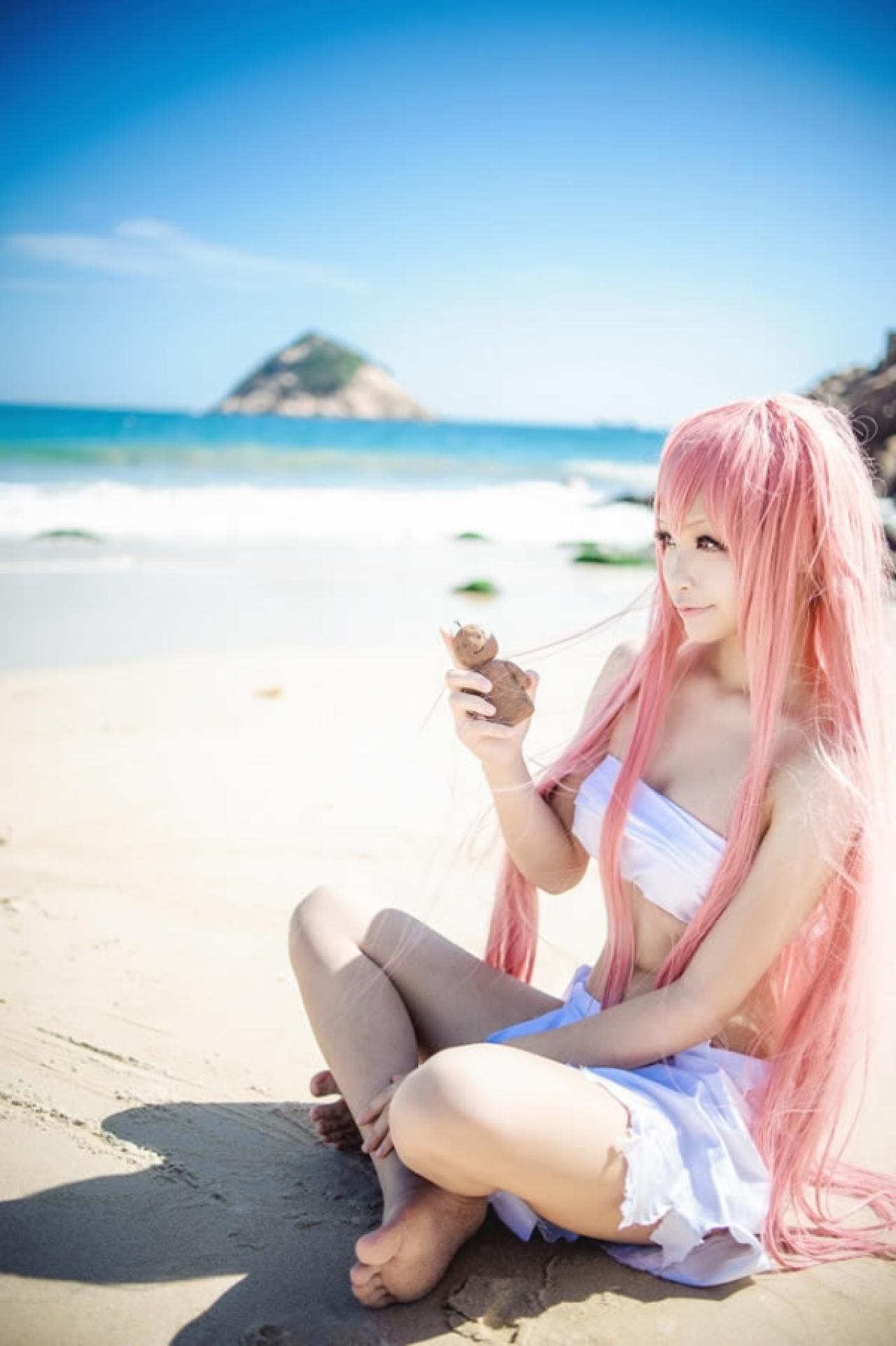 桜木梨扮演锁部叶风穿着白色抹胸拿着小泥人微笑的样子侧面照