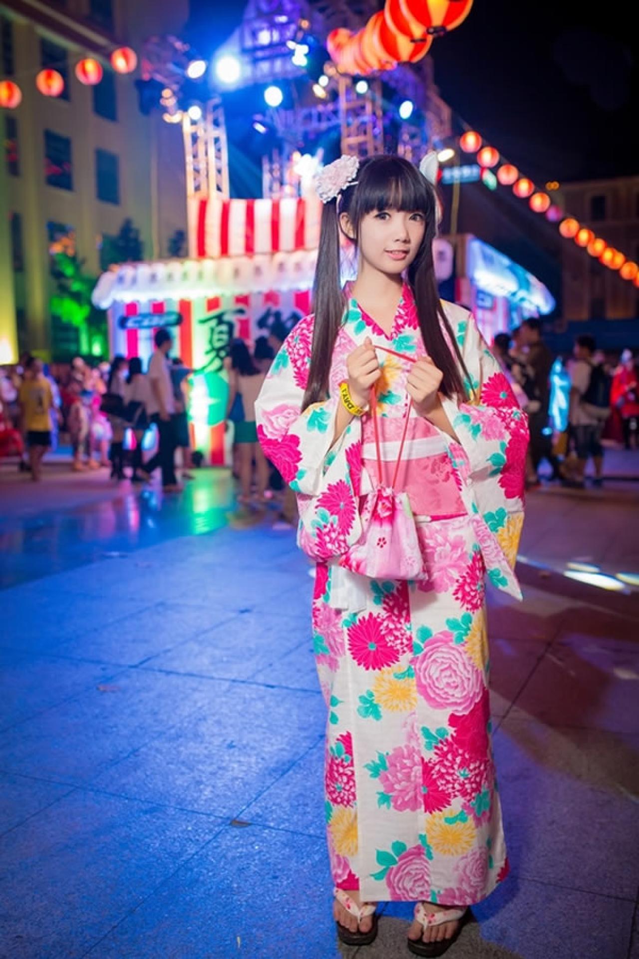 茶叶小果在卡弗动漫游戏展晚间夏日祭粉色和服浴衣街拍，双手拎着束口袋，头微微侧着微笑的样子