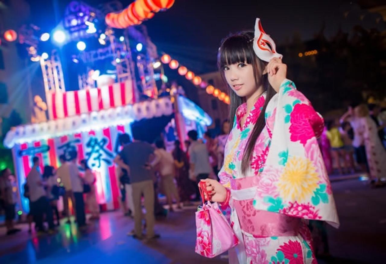 茶叶小果在卡弗动漫游戏展晚间夏日祭粉色和服浴衣街拍，左手捏着面具，右手拎着束口袋，横幅照