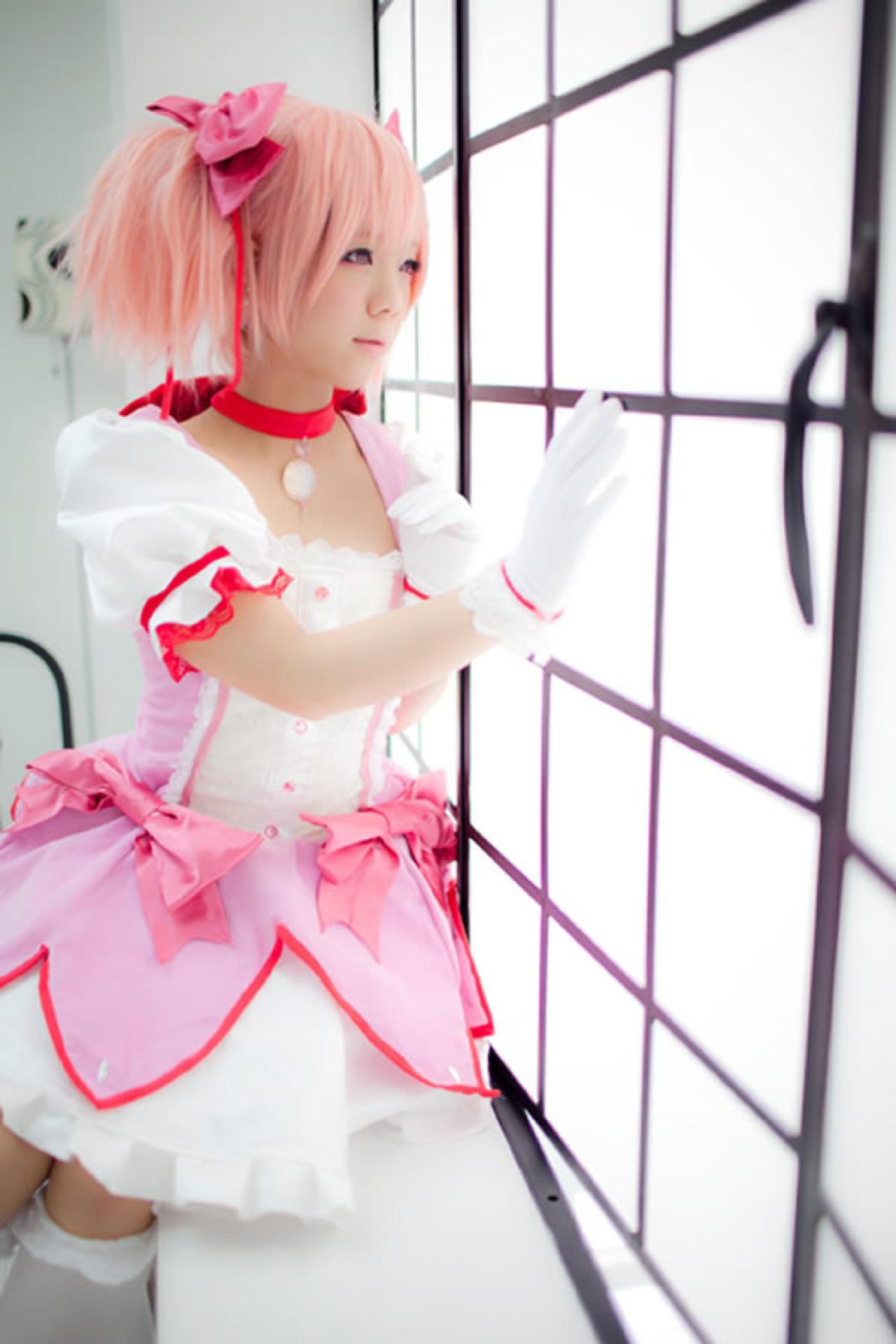 魔法少女鹿月圆香粉衣Cosplay，手扶着落地窗看向窗外的样子