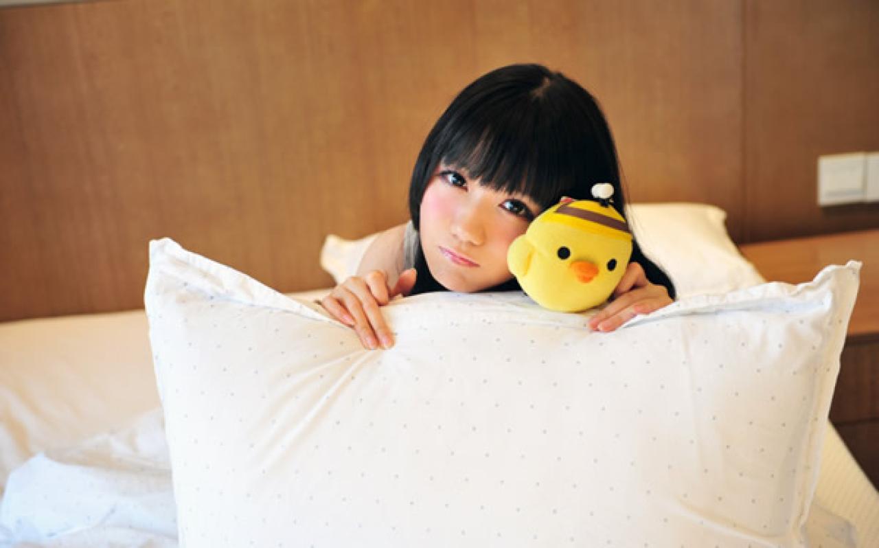 小米藏在枕头后面，拿着小鸡卖个萌