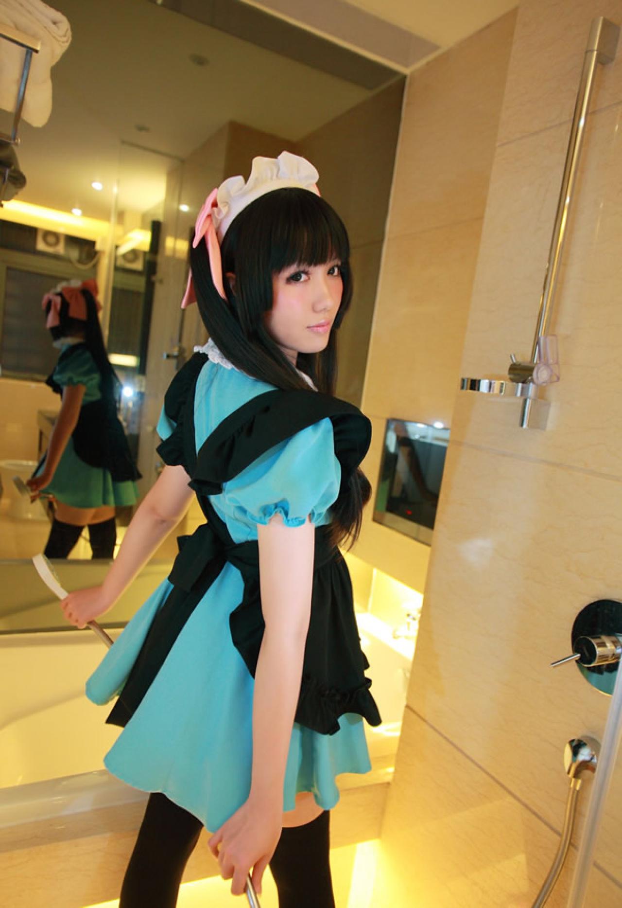 小米穿着绿色女仆装粉红发饰，把淋浴喷头放在身后，背对着镜头，回头笑着