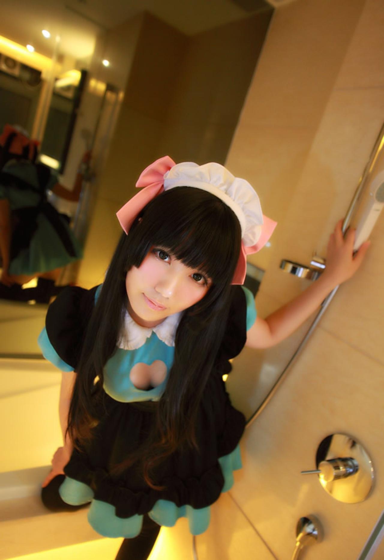 小米穿着绿色女仆装粉红发饰，倾斜身子靠向镜头的样子