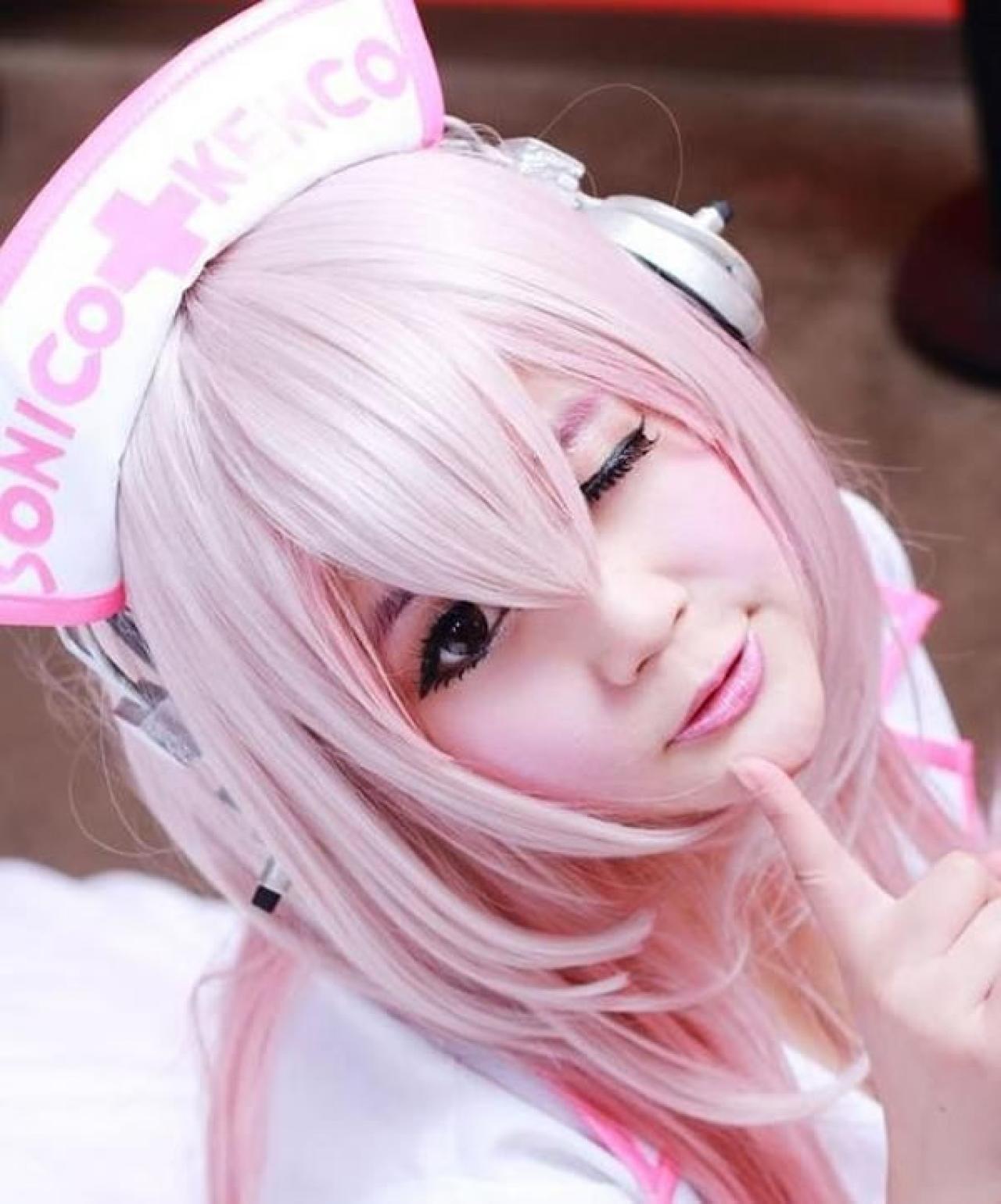 小樱笨笨熊扮演超级索尼子穿着粉色护士服，睁一只眼，闭一只眼，食指放在嘴唇下面，作嘘的调皮样子