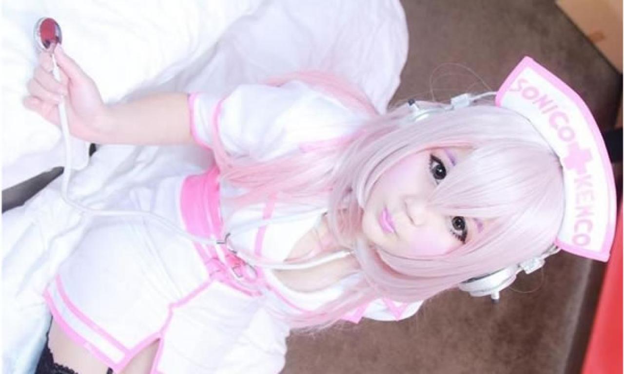 小樱笨笨熊扮演超级索尼子穿着粉色护士服，戴着听诊器坐在床上嘟嘴卖萌的样子