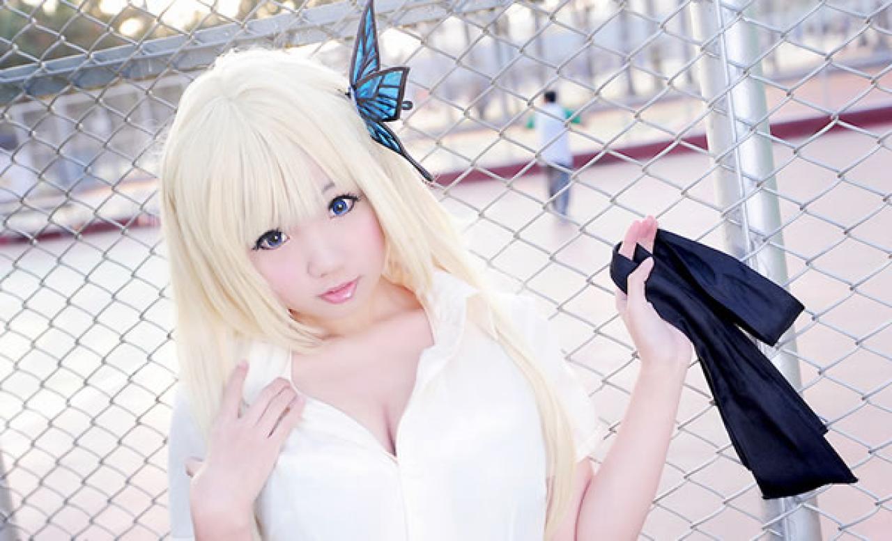 Neneko扮演柏崎星奈脱掉墨绿学院服外套，穿着白色衬衫，一手拿着外套，一手扶着衣领，靠在操场旁的铁丝网上