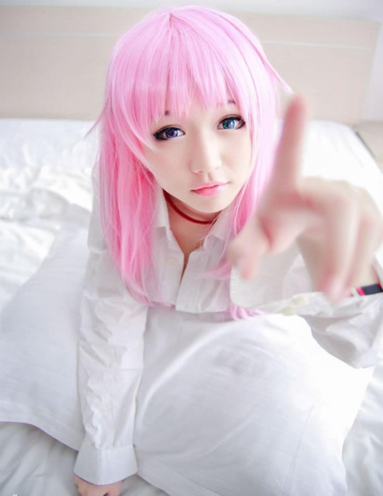 摆摆扮演《K》粉色猫娘，抱着枕头食指指向镜头的姿势