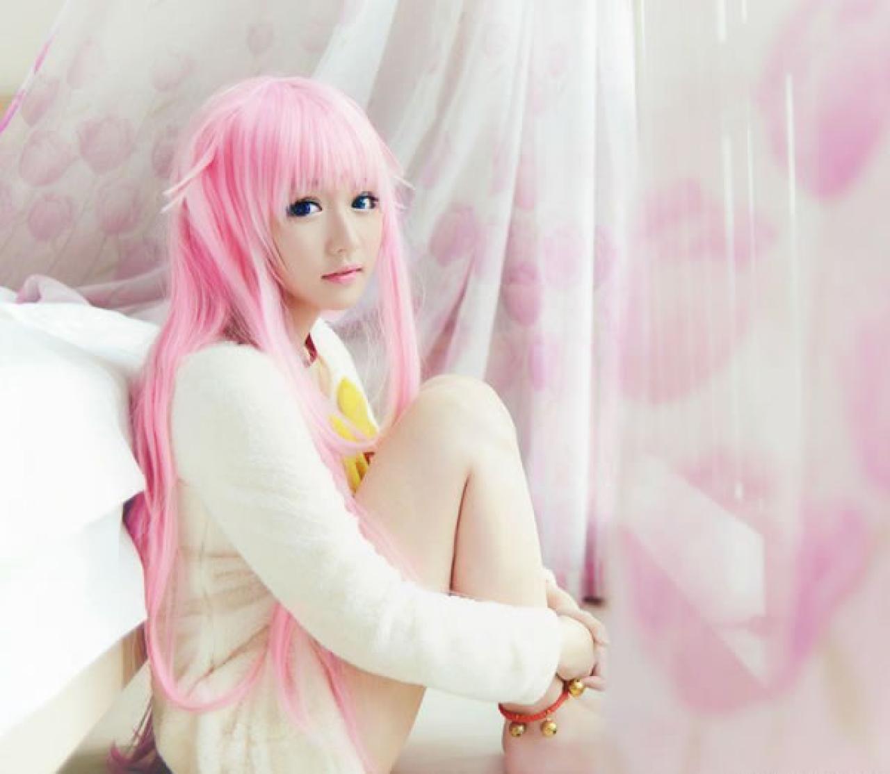 摆摆扮演《K》粉色猫娘，蜷缩着身体靠在床边，侧脸看镜头