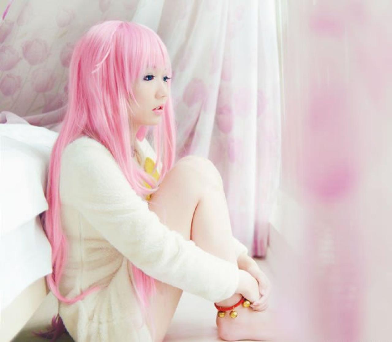 摆摆扮演《K》粉色猫娘，蜷缩着身体靠在窗边，双目平视前方