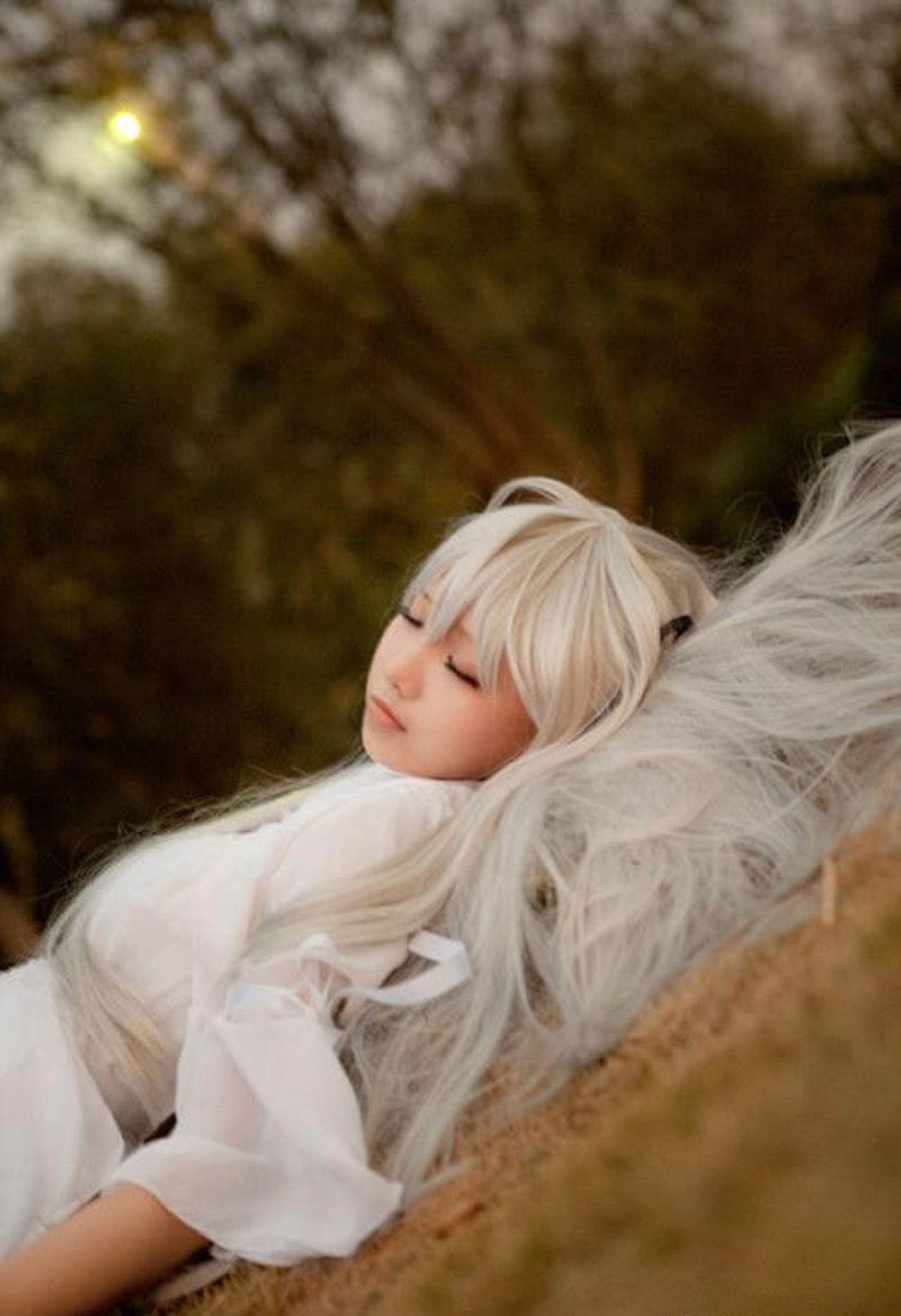 哀子扮演穹妹穿着白色连衣裙躺在枯黄的草地上