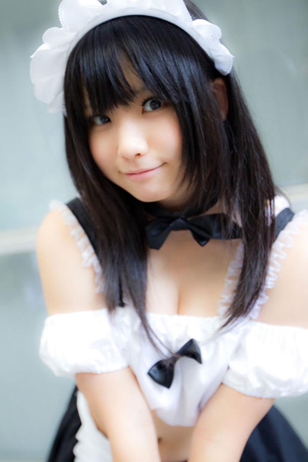 enako穿着黑白女仆装双手自然下垂叠在一起，微笑的样子，像是说欢迎光临