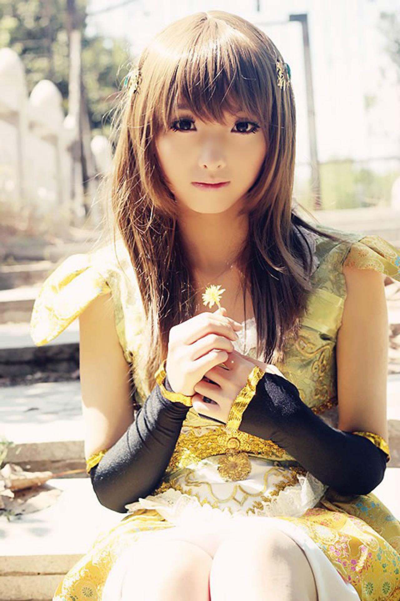 CC喵穿着黄色古装扮演小乔手拿一只小花，坐在台阶上黯然失神的样子