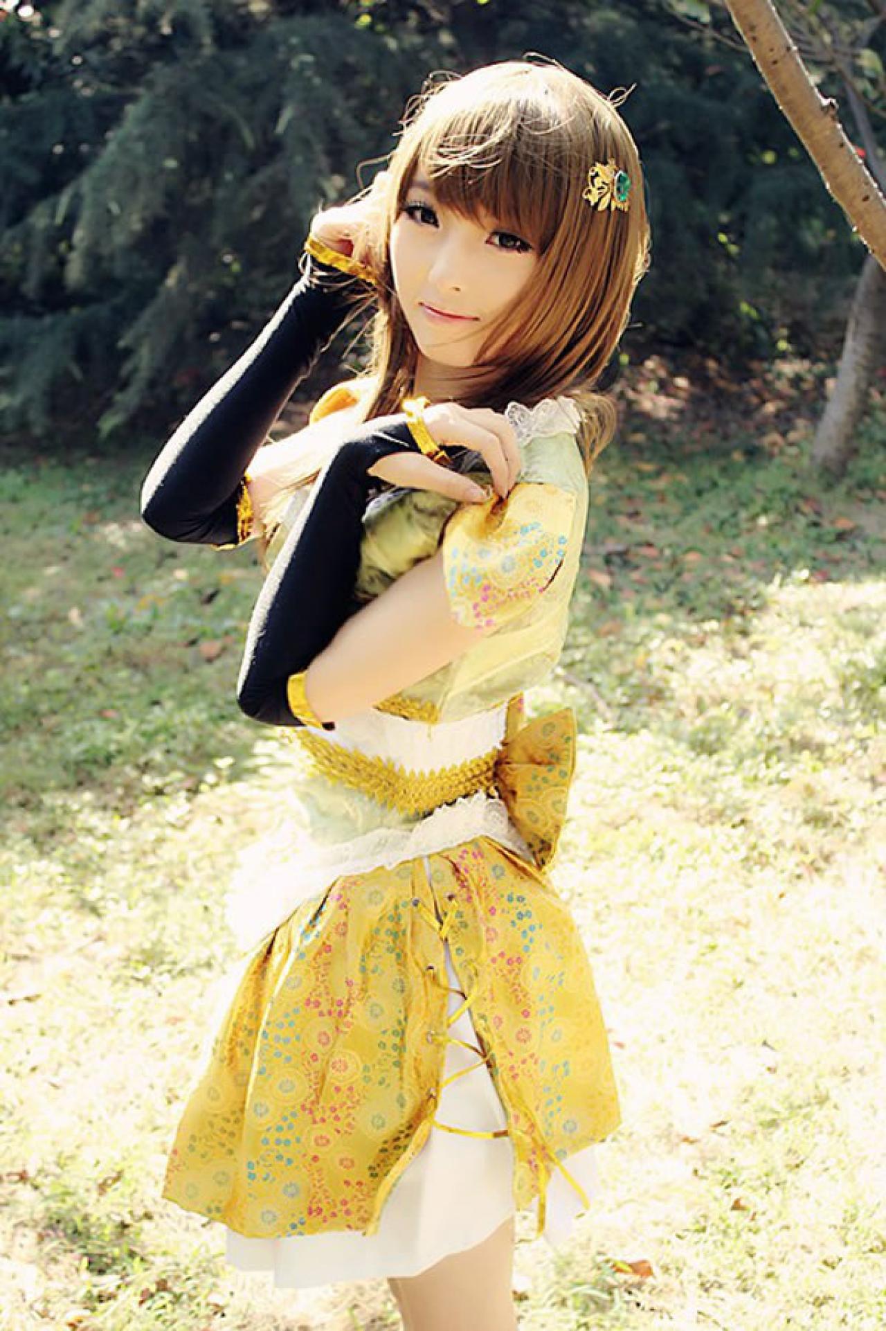 CC喵穿着黄色古装扮演小乔左手扶着肩膀，有着轻抚秀发，侧面照