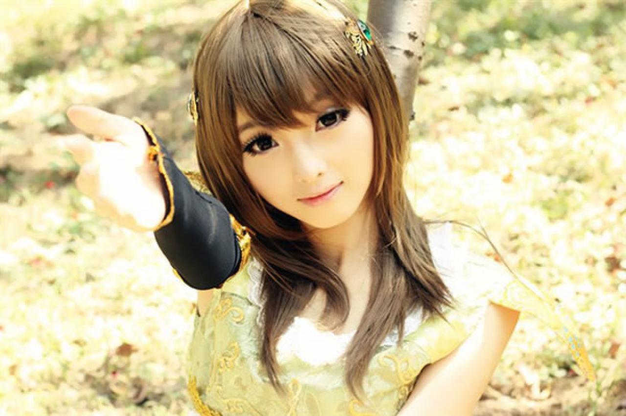 CC喵穿着黄色古装扮演小乔伸出右手，好像在召唤的样子