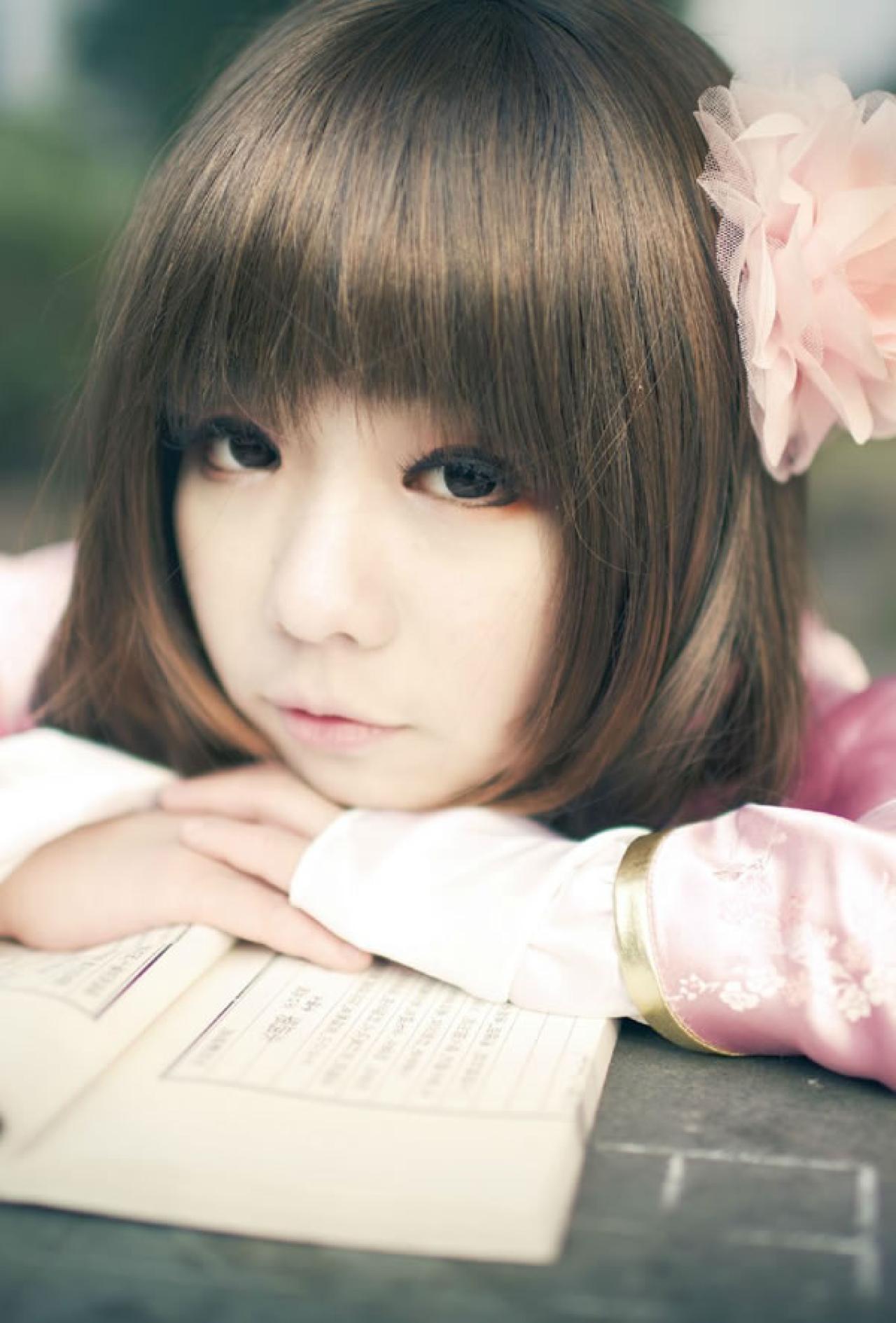 季_凋葬穿着粉衣扮演湾娘趴在石桌上大眼睛眨巴眨巴卖萌的立幅