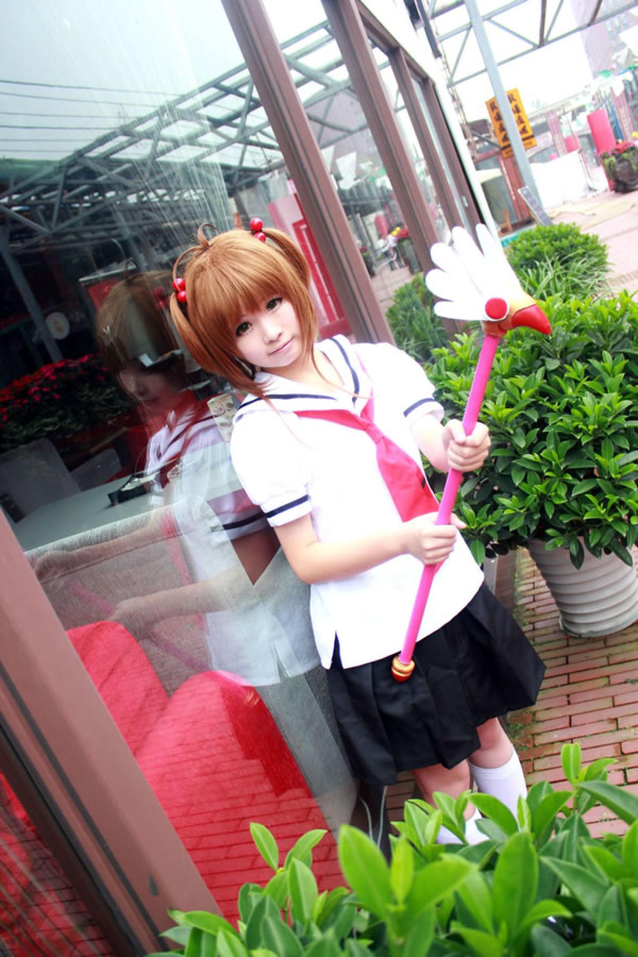 米兔扮演魔法少女穿着校服，举着魔法杖在餐厅门口