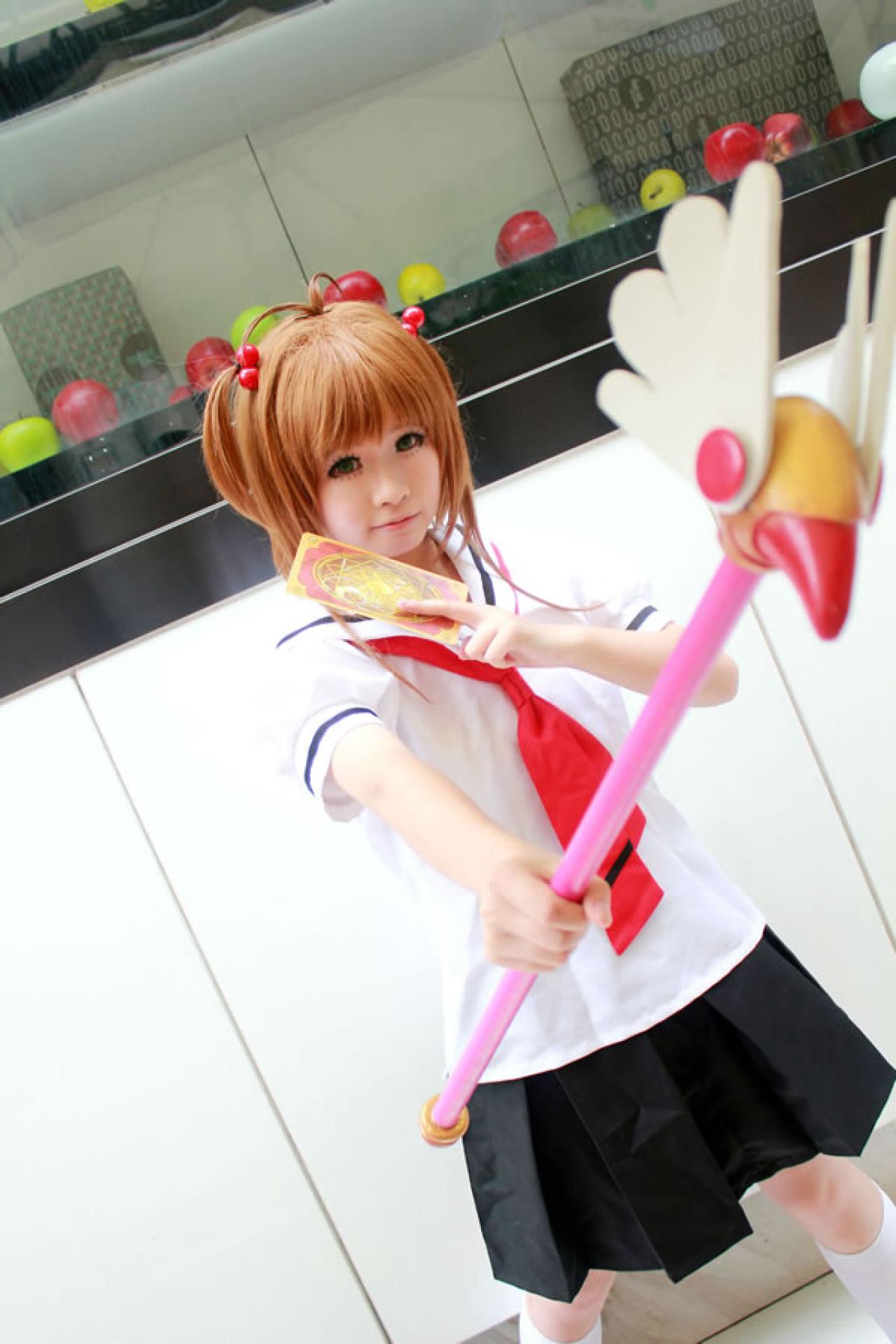 米兔扮演魔法少女穿着校服一手拿着卡牌，一手举着魔法杖