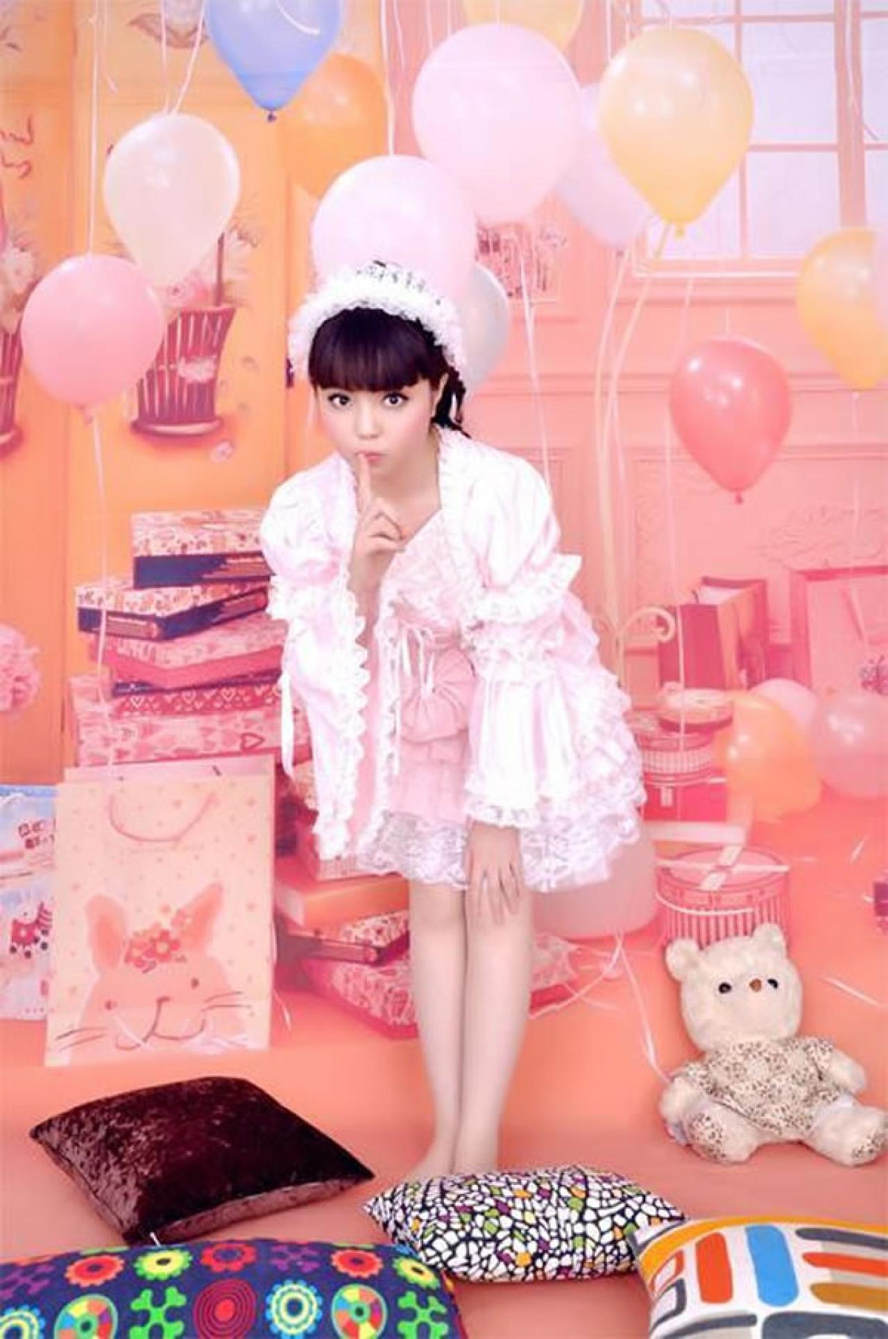 魔法少女大道寺知世穿着粉色公主裙前身微曲，一手指放在嘴唇前，作嘘的手势